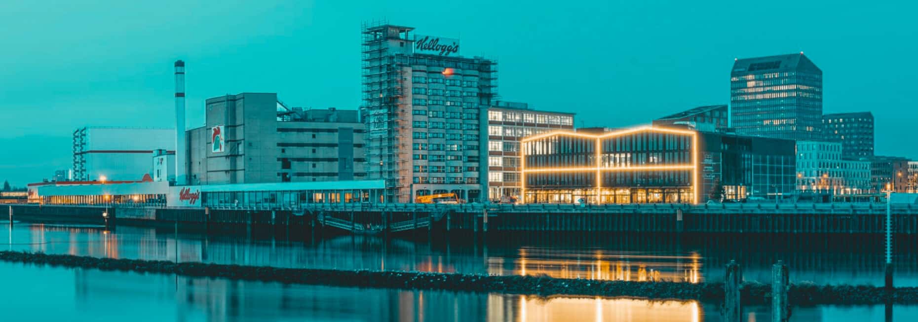 Skyline of Bremen’s Überseeinsel at sunset – riverside urban district with a view of the John & Will hotel