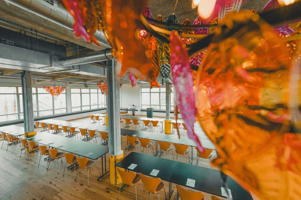 Rows of tables and chairs in the Boven 7 event space at the John & Will hotel in Bremen, set up for conferences or workshops