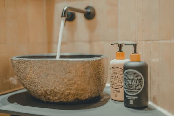 Close-up of a stone Balinese washbasin at the John & Will hotel in Bremen – with sustainable Eco Essentials toiletries