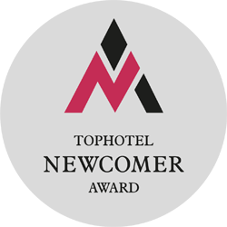 Grafik eines Siegels mit der Aufschrift „TopHotel Newcomer Award“ – das John & Will Hotel wurde mit diesem Preis ausgezeichnet.