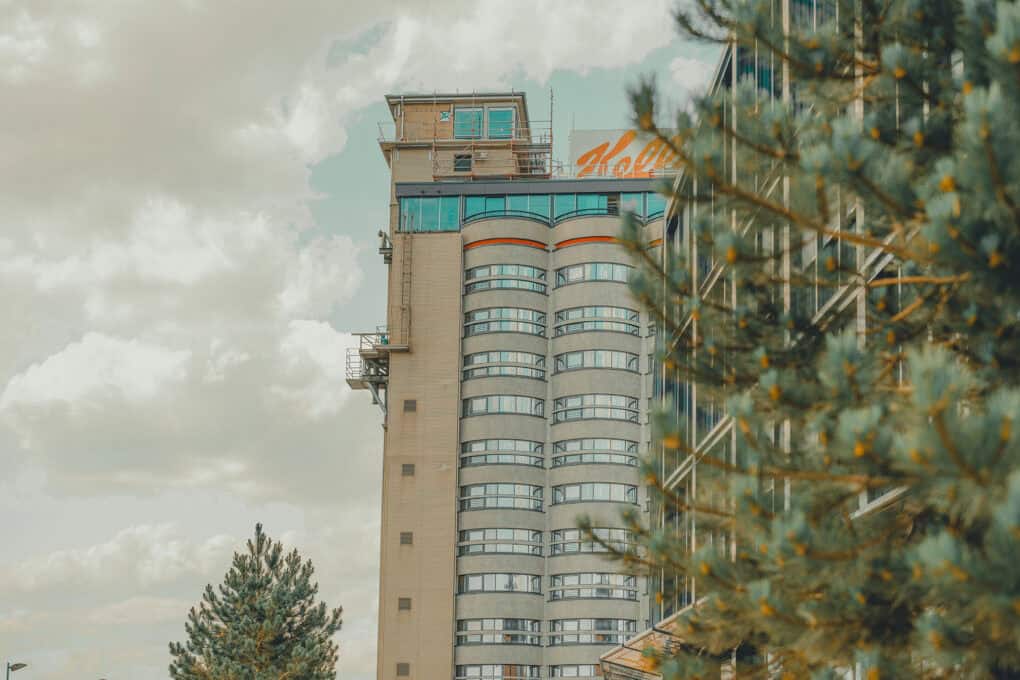 Blick auf das John & Will Hotel Bremen im nachhaltigen Quartier Überseeinsel, eingerahmt von Bäumen und urbanem Grün