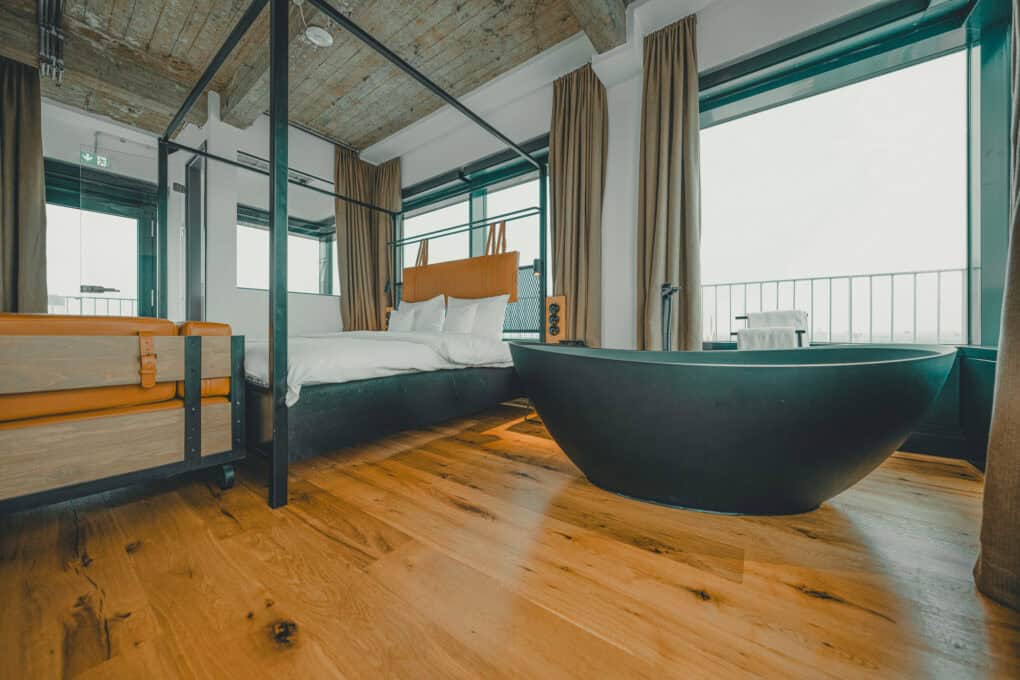 Toorn Stuuv im John & Will Hotel Bremen mit freistehender Badewanne direkt neben dem Doppelbett – Designsuite mit besonderem Charakter