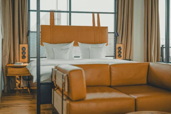 Gemütliches Ledersofa in der Toorn Stuuv im John & Will Hotel Bremen – im Hintergrund das Doppelbett der stilvollen Suite