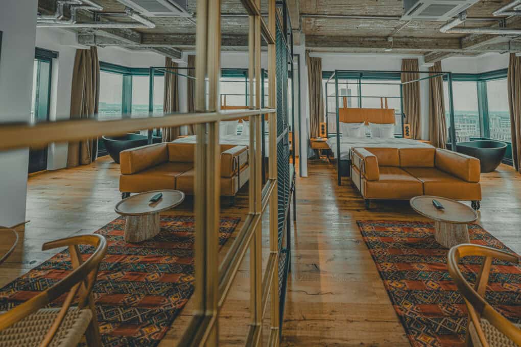 Toorn Stuuv im John & Will Hotel Bremen – 42 m² große Suite mit freistehender Badewanne, Doppelbett, Ledersofa und Esstisch mit Blick über die Weser